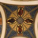 Die reich verzierte Decke des Friedenspalastes in Den Haag ist mit blauen und goldenen Mustern geschmückt und weist in der Mitte des Schnittpunkts vier religiöse Ikonengemälde in ovalen Rahmen auf.