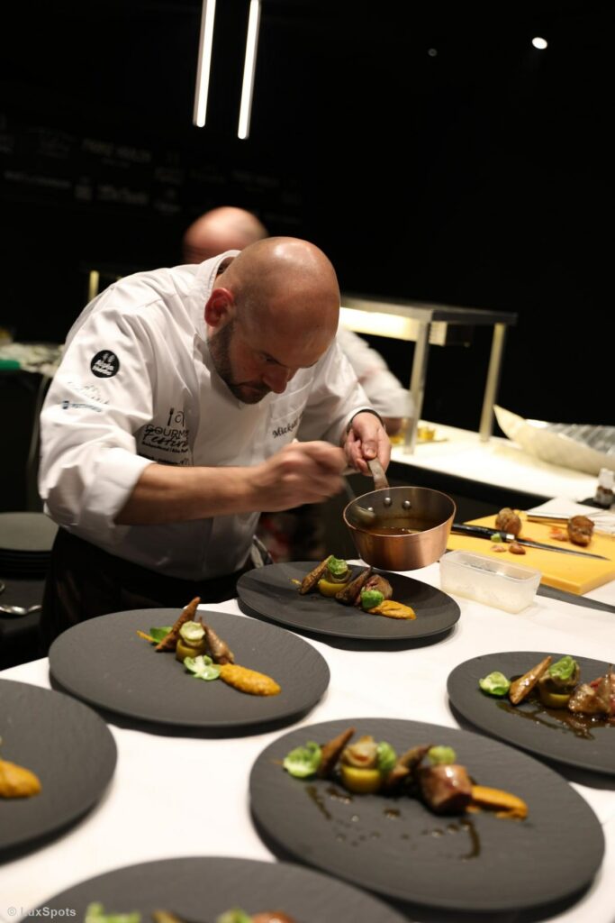 Koch richtet Gourmetgerichte mit Präzision in einer professionellen Event-Küche an.