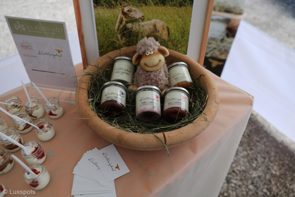 Gläser mit Schafsmilchprodukten in einer Schüssel, darauf ein Plüschschaf.