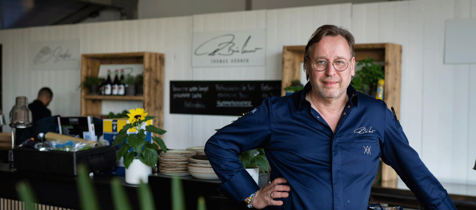 Chefkoch Thomas Bühner am Tresen des VIP-Zelts auf der Porsche European Open 2023