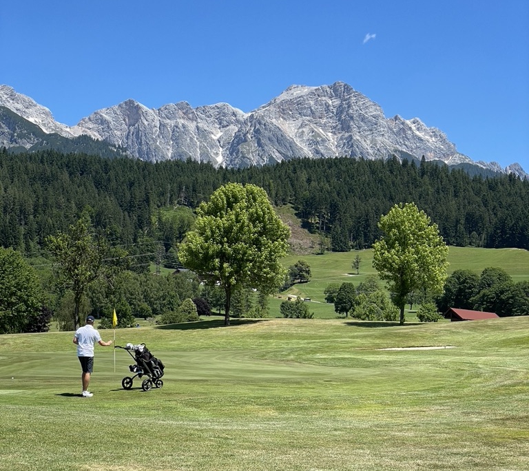 Golfspieler vor Alpenlandschaft im Golfclub Urslautal