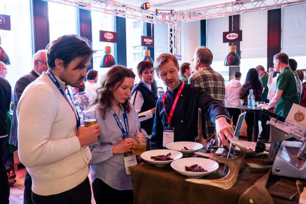 Während der Indoor-Veranstaltung Gastro Vision in Hamburg lassen sich zwei Besucher an einem Stehtisch verschiedene getrocknete Fleischsorten von einem Anbieter erläutern.