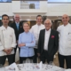 Vier bekannte Köche und zwei Herren in Anzügen lächeln in einem großen Saal in die Kamera. Sie sind das Team zur Eröffnung des 38. Schleswig-Holstein Gourmet Festivals in Pinneberg bei Hamburg.