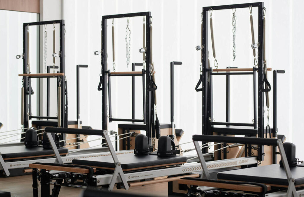 Drei moderne Fitnessgeräte stehen in einem hell weißen Raum.