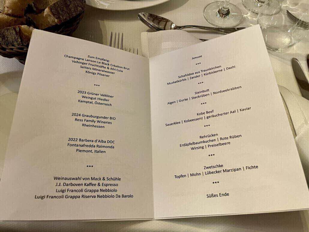 Eine geöffnete Speisekarte zeigt die Gerichte und Weine, die an diesem Abend serviert werden.